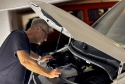 man looking under the hood of a car